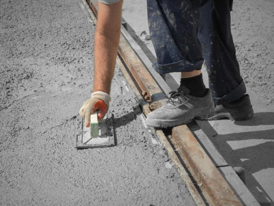 Worker using trowel to repair concrete expansion joint on commercial building facade